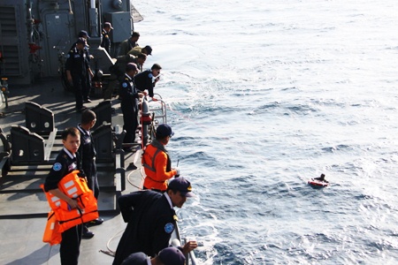 Thai Navy crewmen aboard the HTMS Similan pluck from the sea survivors of the Sirichai Nava 11 that had been sunk after Somali pirates hijacked it in the Gulf of Eden.